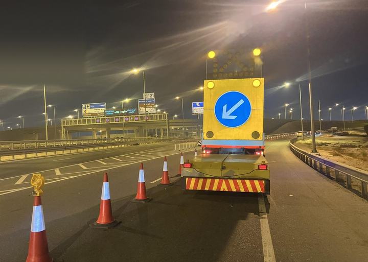 TMA with arrow board leading a cone taper on a highway at night