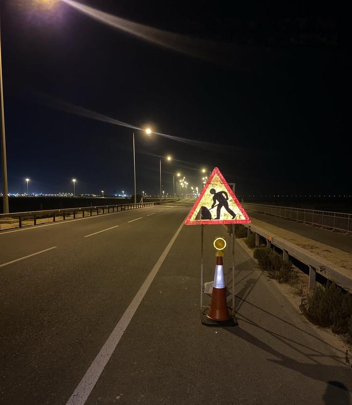 Roadworks warning sign on a coned shoulder