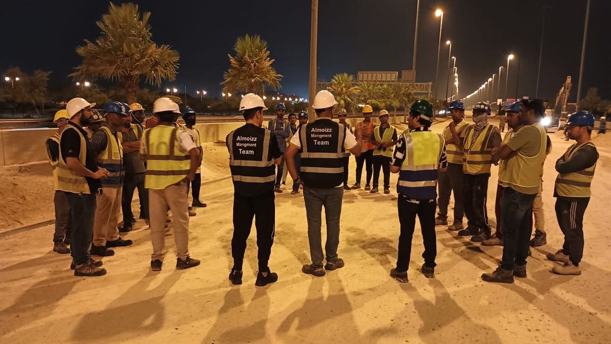 Al Moizz site crew in PPE during a toolbox talk before shift