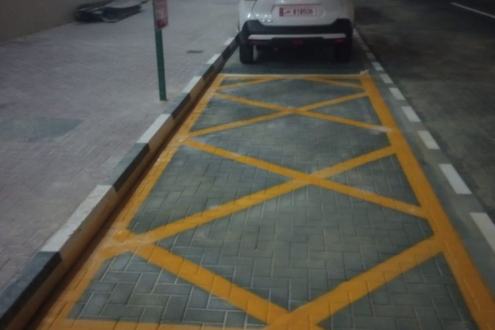 Completed yellow hatch road marking with kerb and paving